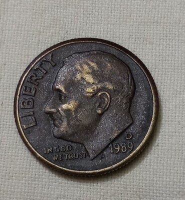 1989 dime missing clad layer error showing copper-red exposed surface where nickel outer layer failed to bond
