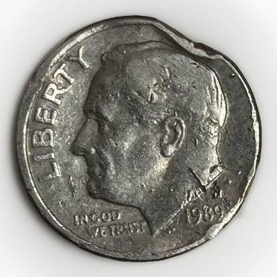 1989 dime clipped planchet error showing curved crescent-shaped missing section at edge with Blakesley effect visible on opposite rim